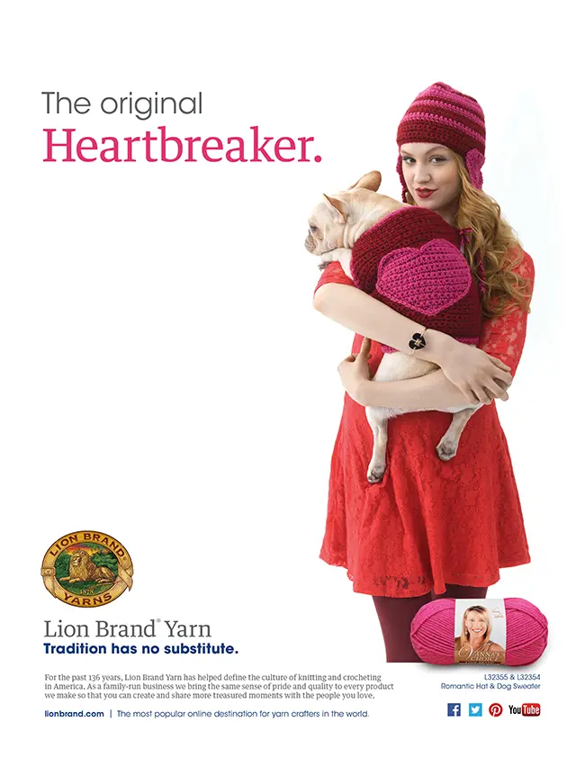 A woman in a red dress and a pink crocheted hat, holding a small dog wearing a matching pink crocheted sweater. They are positioned against a plain white background, with the woman looking at the camera with a playful expression. The text "The original Heartbreaker" appears at the top.